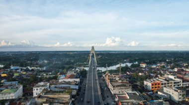Aerial view of Siak Bridge IV (Abdul Jalil Alamuddin Syah Bridge) above Siak River (Sungai Siak) in Pekanbaru top view. Pekanbaru, Indonesia, January 25, 2023