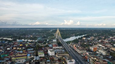 Aerial view of Siak Bridge IV (Abdul Jalil Alamuddin Syah Bridge) above Siak River (Sungai Siak) in Pekanbaru top view. Pekanbaru, Indonesia, January 25, 2023