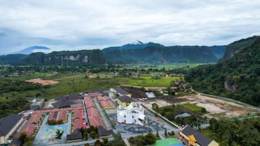 Aerial view of white mosque in a beautiful landscape view of Harau Valley with mountains valley and grass view, Beautiful Minangkabau. West Sumatera, Indonesia, january 26, 2023