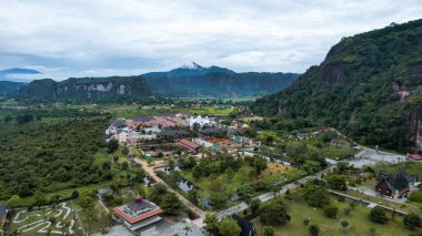 Aerial view of white mosque in a beautiful landscape view of Harau Valley with mountains valley and grass view, Beautiful Minangkabau. West Sumatera, Indonesia, january 26, 2023