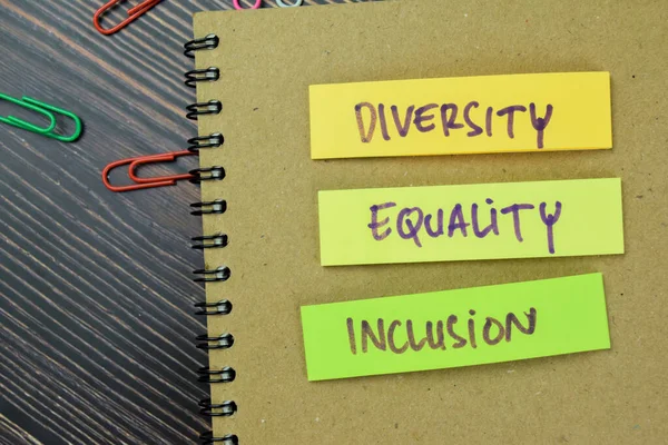 Concept of Diversity, Equality, Inclusion write on sticky notes isolated on Wooden Table.