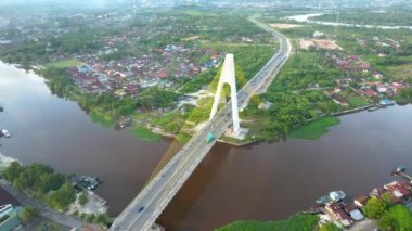 Aerial view of Siak Bridge IV (Abdul Jalil Alamuddin Syah Bridge) above Siak River (Sungai Siak) in Pekanbaru top view. Pekanbaru, Indonesia, February 22, 2023