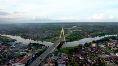 Aerial view of Siak Bridge IV (Abdul Jalil Alamuddin Syah Bridge) above Siak River (Sungai Siak) in Pekanbaru top view. Pekanbaru, Indonesia, February 22, 2023