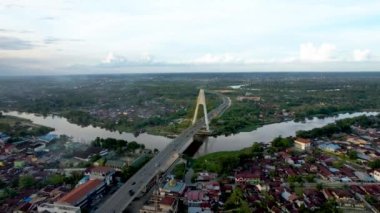 Aerial view of Siak Bridge IV (Abdul Jalil Alamuddin Syah Bridge) above Siak River (Sungai Siak) in Pekanbaru top view. Pekanbaru, Indonesia, February 22, 2023