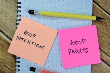 Concept of Good Intentions and Good Results write on sticky notes isolated on Wooden Table. clipart