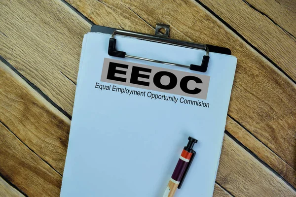 Concept of EEOC - Equal Employment Opportunity Commision write on paperwork isolated on Wooden Table.
