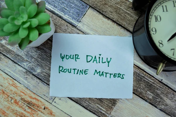 Concept of Your Daily Routine Matters write on sticky notes isolated on Wooden Table.