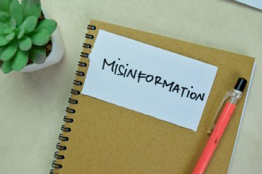 Concept of Misinformation write on sticky notes isolated on Wooden Table. clipart