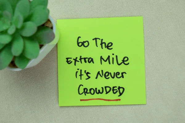 stock image Concept of Go The Extra Mile It's Never Crowded write on sticky notes isolated on Wooden Table.