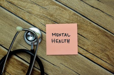 Akıl Sağlığı kavramı, tahta masaya stetoskop ile izole edilmiş yapışkan notlara yazılır..