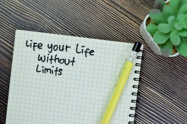 Concept of Life Your Life Without Limits write on book isolated on Wooden Table.