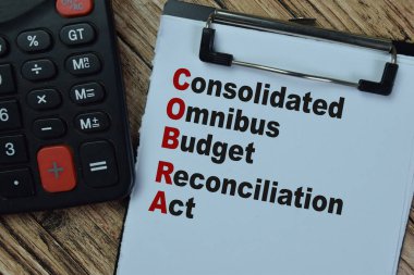 Concept of COBRA - Consolidated Omnibus Budget Reconciliation Act write on paperwork isolated on Wooden Table. clipart