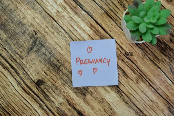 木のテーブルに隔離された付箋に妊娠記の概念 — ストック写真