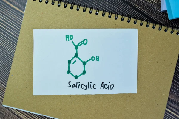 化学分子式ホルモンの概念木製のテーブルに隔離された付箋にサリチル酸を書き込みます — ストック写真