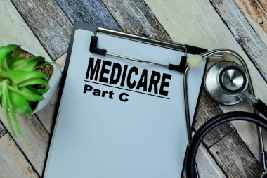 Medicare Bölüm C kağıt üzerinde steteskopla Tahta Masa 'ya izole edilmiş..