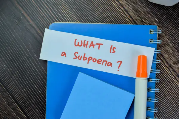 木製のテーブルに隔離された粘着性のあるノートにSubpoenaが書くものの概念 — ストック写真