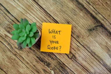 Concept of What is Your Score? write on sticky notes isolated on Wooden Table. clipart