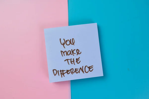 Concept of You Make The Difference write on sticky notes isolated on Wooden Table.