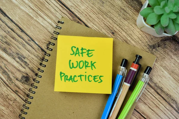 Concept of Safe Work Practices write on sticky notes isolated on Wooden Table.