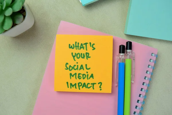 Concept of What\'s Your Social Media Impact? write on sticky notes isolated on Wooden Table.