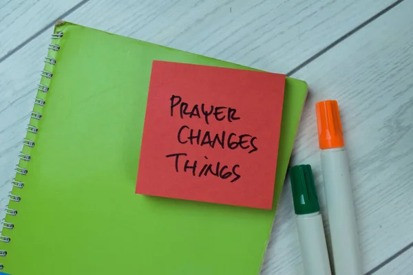 Concept of Prayer Changes Things write on sticky notes isolated on Wooden Table.