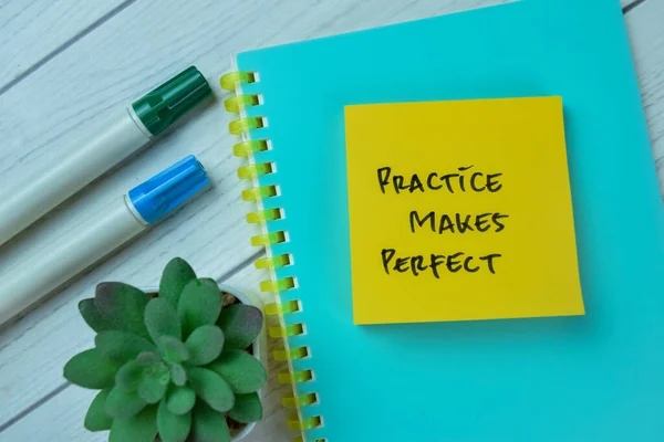 Concept of Practice Makes Perfect write on sticky notes isolated on Wooden Table.