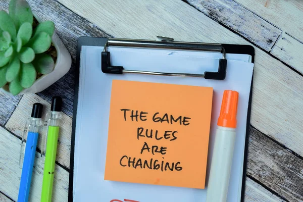 Concept of The Game Rules Are Changing write on sticky notes isolated on Wooden Table.