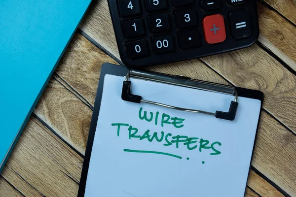 Concept of Wire Transfers write on paperwork isolated on Wooden Table.