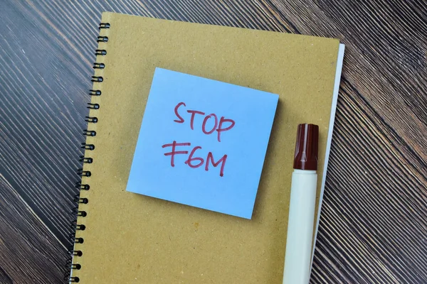 木製テーブルに隔離された粘着性のあるノートにFgmの書き込みを停止する概念 — ストック写真