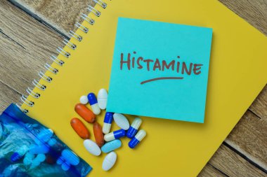Concept of Histamine write on sticky notes isolated on Wooden Table. clipart