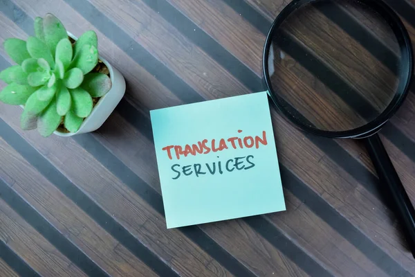 Concept of Translation Services write on sticky notes isolated on Wooden Table.
