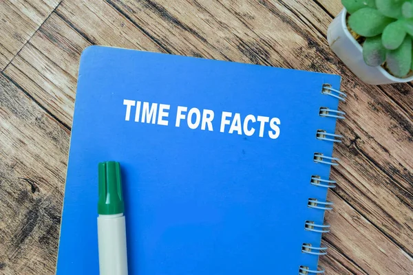 Concept of Time For Facts write on book isolated on Wooden Table.