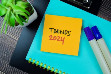 2024 Eğilimleri kavramı Tahta Masa 'da izole edilmiş yapışkan notlara yazılır.
