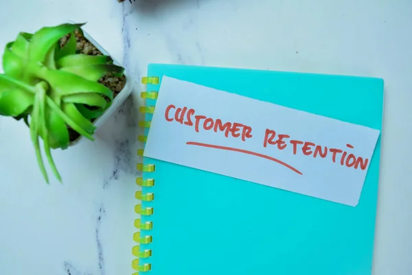 Concept of Customer Retention write on sticky notes isolated on Wooden Table.