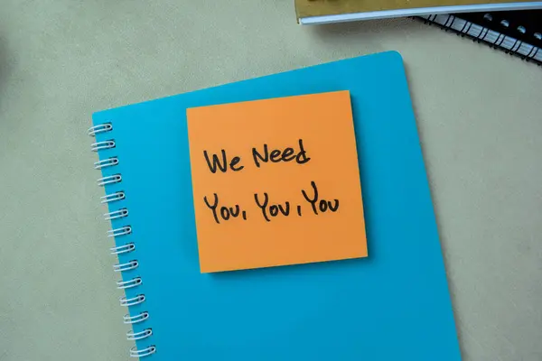 Concept of We Need You, You, You write on sticky notes isolated on Wooden Table.
