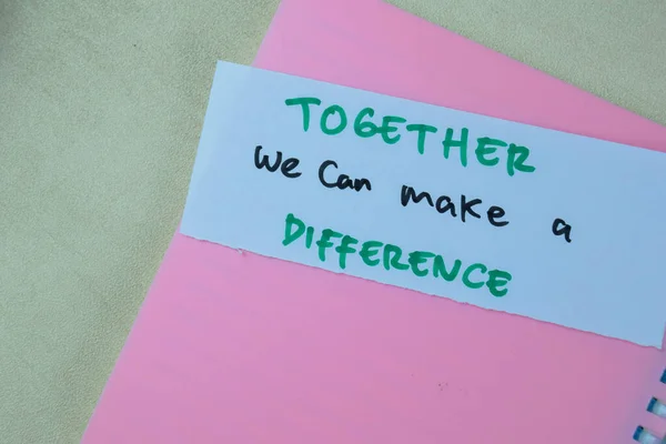 Concept of Together we can make a Difference write on sticky notes isolated on Wooden Table.