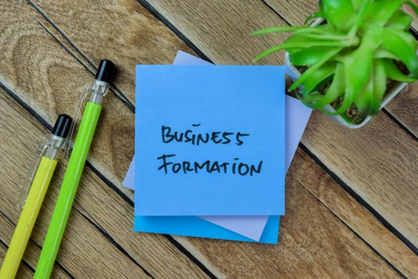 Concept of Business Formation write on sticky notes isolated on Wooden Table.