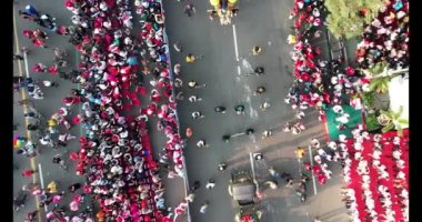 Ahmad Yani caddesi Bekasi iş bölgesi boyunca arabasız geçen büyük kalabalığın hava görüntüsü de arabaya katılıyor. Bekasi, Endonezya 13 Ekim 2023