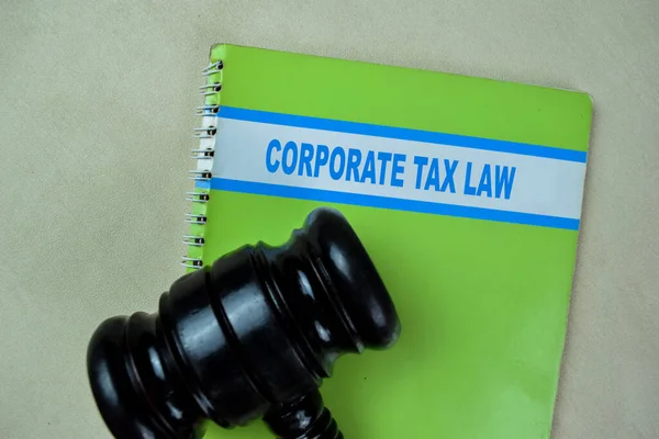 Concept of Corporate Tax Law write on book with Gavel isolated on Wooden Table.