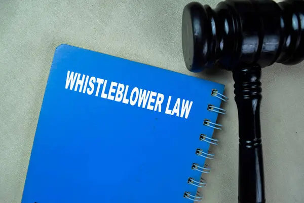 Concept of Whistleblower Law write on book isolated on Wooden Table.