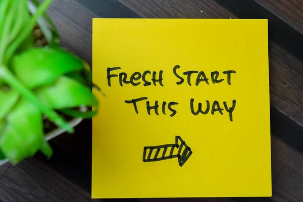 Concept of Fresh Start This Way write on sticky notes isolated on Wooden Table.