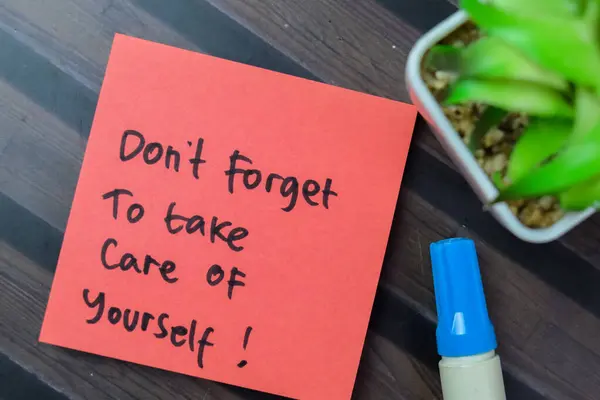 Concept of Don\'t Forget To Take Care Of Yourself! write on sticky notes isolated on Wooden Table.
