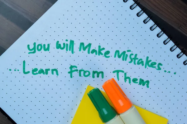 Concept of You Will Make Mistakes, Learn From Them write on book isolated on Wooden Table.