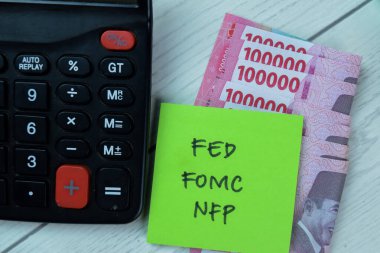 FED, FOMC ve NFP kavramları, steteskop ile izole edilmiş yapışkan notlar üzerine yazılır..