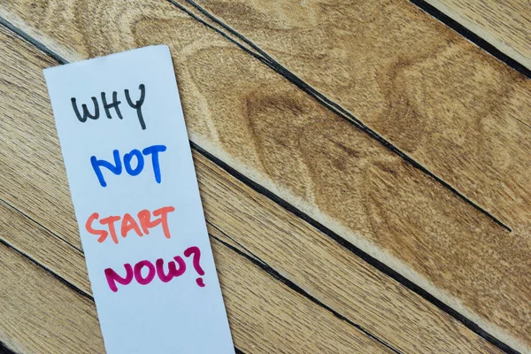 Concept of Why Not Start Now? write on sticky notes isolated on Wooden Table.