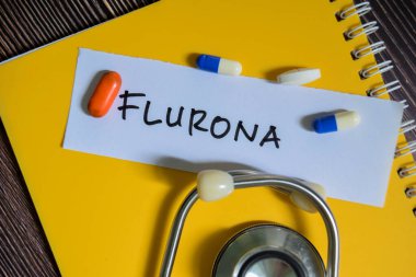 Flurona kavramı, ahşap masa üzerine izole edilmiş steteskop ile yapışkan notlara yazılır..