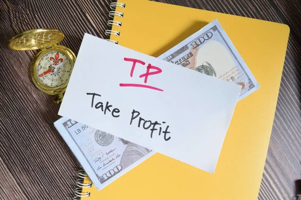 Concept of TP - Take Profit write on sticky notes isolated on Wooden Table.