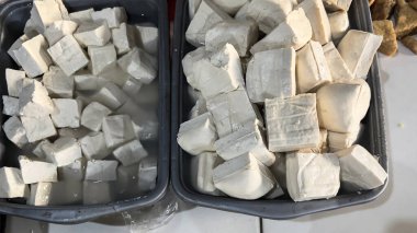 Taze tofu derisi ve geleneksel Endonezya pazarlarında paslanmaz tepside ham ipek tofu kalıpları.