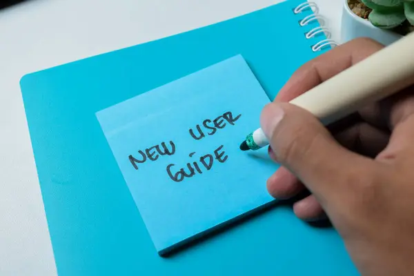 Concept of New User Guide write on sticky notes isolated on white background.
