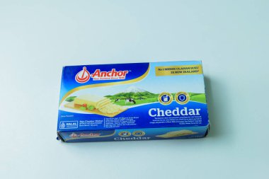 Beyaz arka planda ANCHOR Cheddar Cheese dilimleri. Bekasi, Endonezya, 14 Aralık 2023